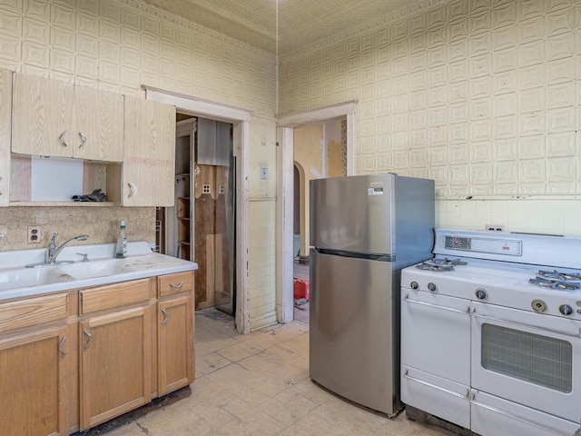 4028 W Roscoe St, Chicago, IL 60641 - kitchen with white gas range oven, freestanding refrigerator, a sink, and light countertops