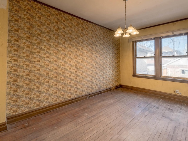 4028 W Roscoe St, Chicago, IL 60641 - spare room with a chandelier, hardwood / wood-style floors, crown molding, and baseboards