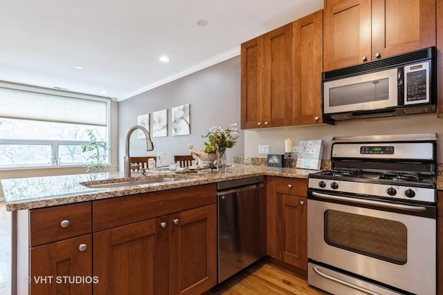934 W Cuyler Ave Unit 2D, Chicago, IL 60613 - kitchen featuring appliances with stainless steel finishes, a sink, crown molding, light stone counters, and brown cabinets