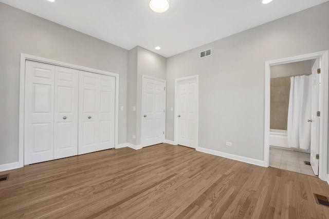 6025 N Ridge Ave Unit 1W, Chicago, IL 60660 - unfurnished bedroom with wood finished floors, ensuite bath, recessed lighting, and a closet