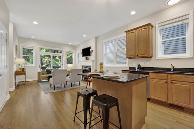 6025 N Ridge Ave Unit 1W, Chicago, IL 60660 - kitchen featuring open floor plan, a breakfast bar, a center island, light wood-style floors, and recessed lighting
