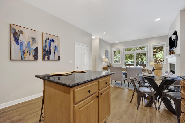 6025 N Ridge Ave Unit 1W, Chicago, IL 60660 - kitchen featuring open floor plan, light wood-style floors, a center island, dark stone countertops, and recessed lighting