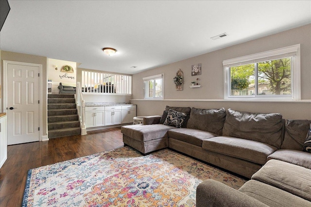 living room with plenty of natural light, dark wood-style flooring, and stairway