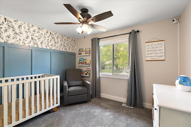 bedroom featuring carpet flooring, a crib, baseboards, and a ceiling fan