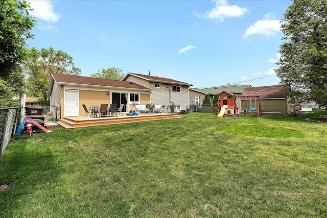 rear view of house with a playground, a wooden deck, and outdoor dining space