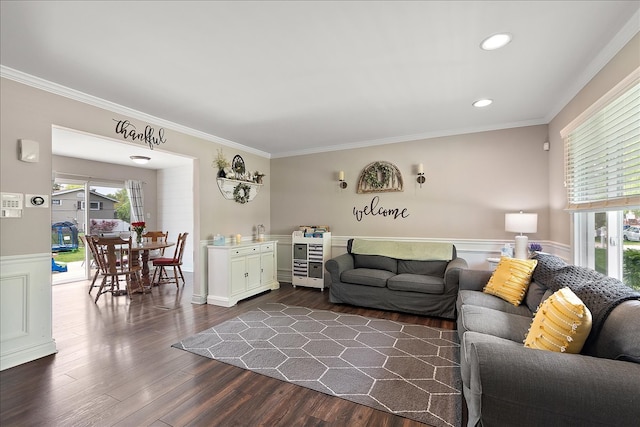 living area with a wainscoted wall, ornamental molding, dark wood-style floors, and recessed lighting