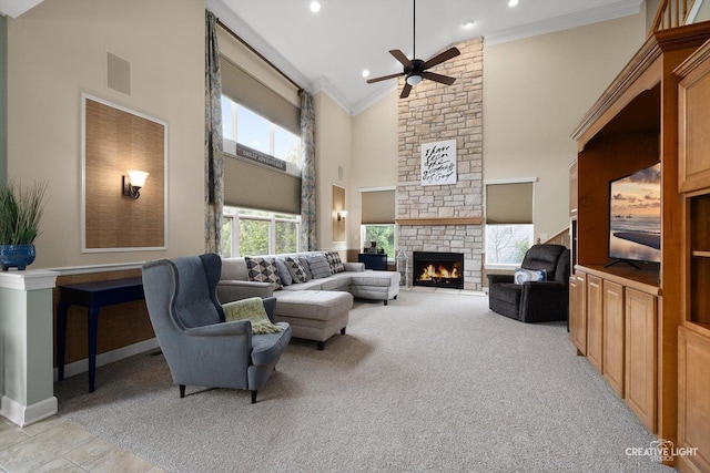 living area featuring high vaulted ceiling, crown molding, a fireplace, ceiling fan, and baseboards