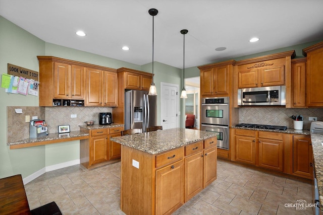 kitchen featuring stainless steel appliances, decorative backsplash, a kitchen island, brown cabinetry, and light stone countertops