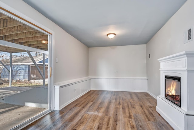 530 Parnell Ave, Chicago Heights, IL 60411 - unfurnished living room featuring wood finished floors, a wainscoted wall, and a glass covered fireplace