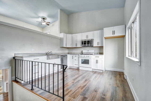530 Parnell Ave, Chicago Heights, IL 60411 - kitchen with stainless steel appliances, white cabinetry, wood finished floors, and a high ceiling
