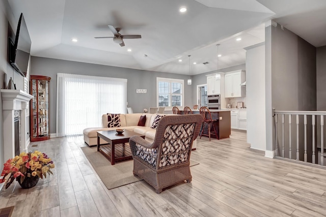 living area featuring ceiling fan, light wood finished floors, recessed lighting, a fireplace, and baseboards