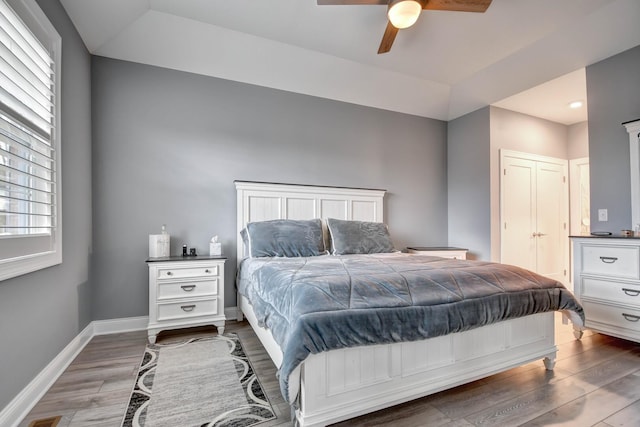 bedroom with wood finished floors, baseboards, and a ceiling fan