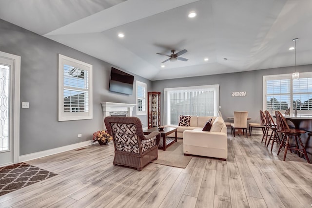 living area featuring light wood-type flooring, ceiling fan, healthy amount of natural light, lofted ceiling, and recessed lighting