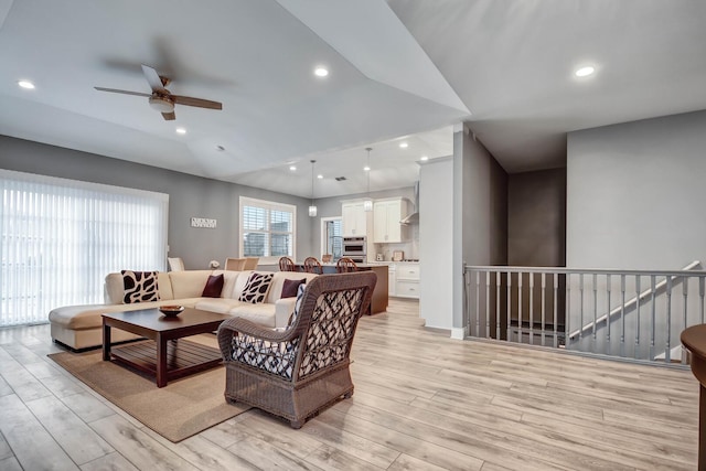 living room featuring a ceiling fan, light wood-style floors, recessed lighting, and lofted ceiling