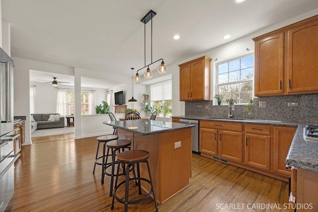 700 Wilmore Dr, Oswego, IL 60543 - kitchen with stainless steel appliances, dark wood-style floors, a sink, open floor plan, and a center island