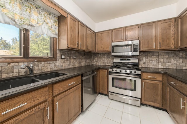 12 James Dr, Westmont, IL 60559 - kitchen with appliances with stainless steel finishes, tasteful backsplash, light tile patterned flooring, a sink, and brown cabinetry