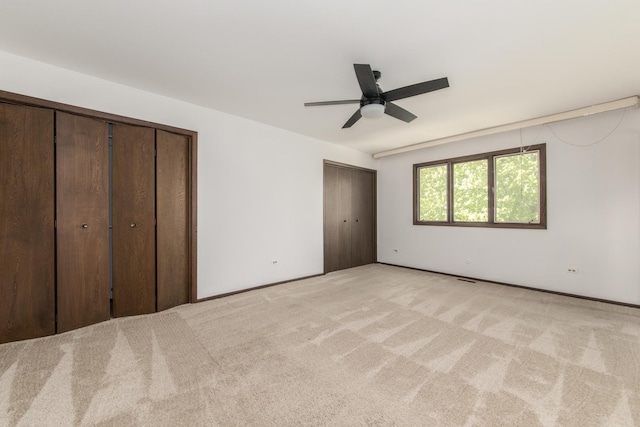 12 James Dr, Westmont, IL 60559 - unfurnished bedroom with multiple closets, light carpet, and ceiling fan