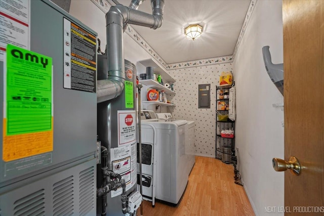 laundry area featuring washer and clothes dryer, heating unit, wood finished floors, wallpapered walls, and electric panel