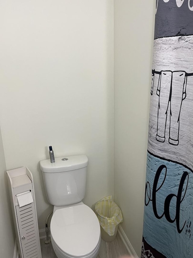 bathroom with baseboards and toilet