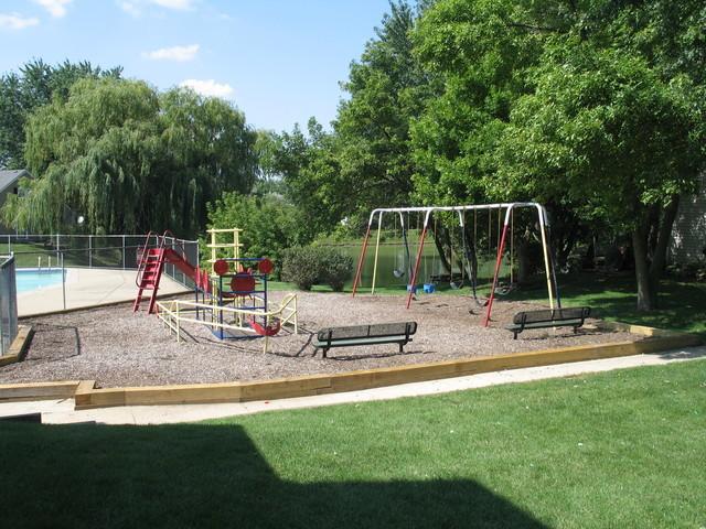 community play area featuring a yard and view of wooded area
