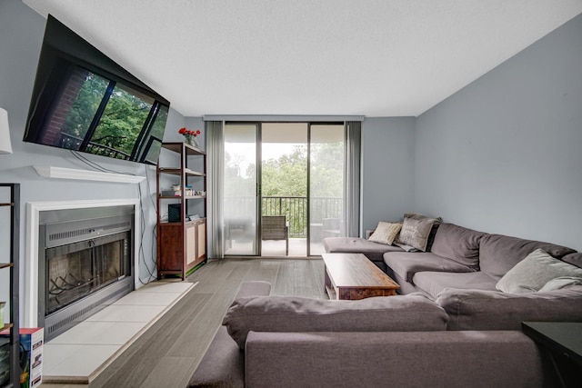 511 Aurora Ave Unit 413, Naperville, IL 60540 - living area featuring a tile fireplace, wood finished floors, and a wall of windows