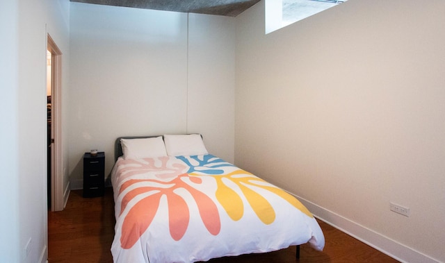 bedroom featuring wood finished floors and baseboards