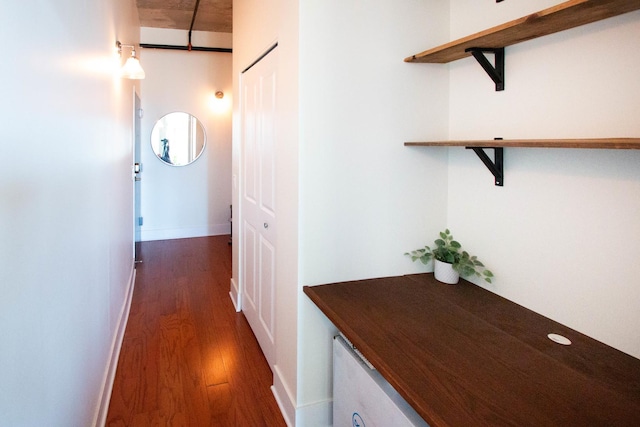 hallway with dark wood-style floors and baseboards