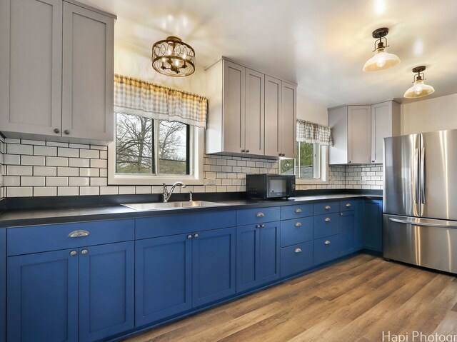 1291 Banbury Rd, Mundelein, IL 60060 - kitchen featuring freestanding refrigerator, blue cabinets, a sink, and dark countertops