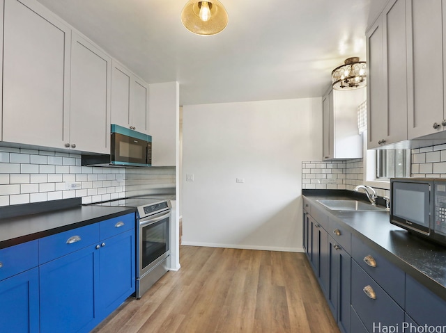 1291 Banbury Rd, Mundelein, IL 60060 - kitchen with electric stove, black microwave, dark countertops, a sink, and blue cabinets