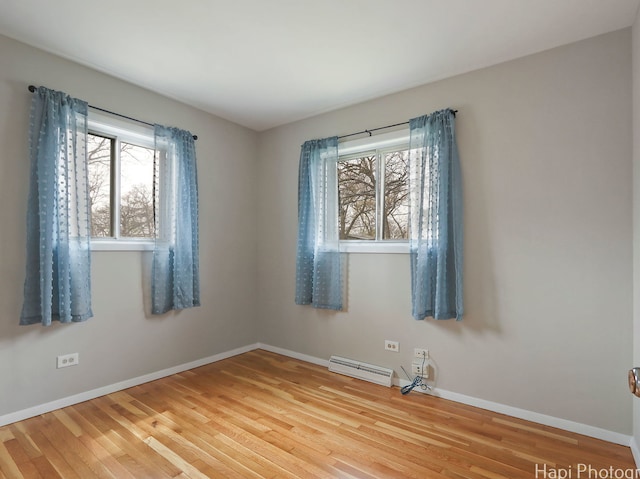 1291 Banbury Rd, Mundelein, IL 60060 - spare room featuring baseboard heating, healthy amount of natural light, wood finished floors, and baseboards