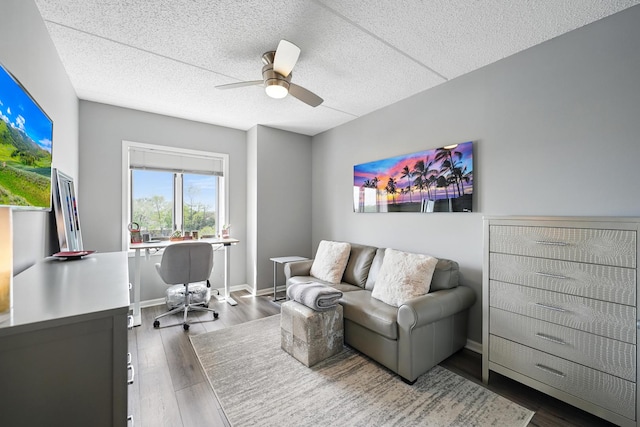 home office with a ceiling fan, a textured ceiling, wood finished floors, and baseboards