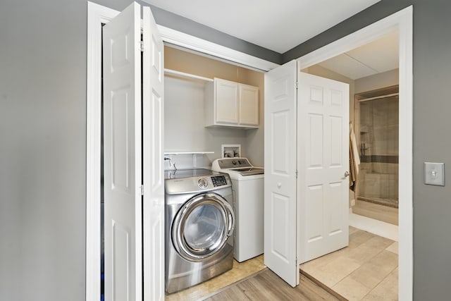 clothes washing area featuring cabinet space and washing machine and dryer