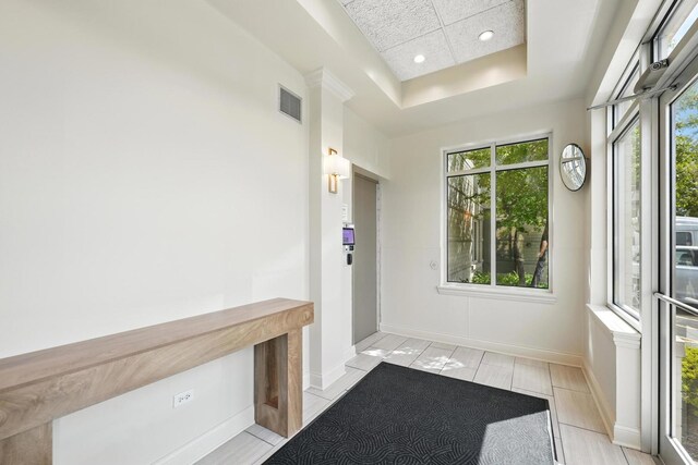 doorway featuring a tray ceiling, baseboards, and recessed lighting