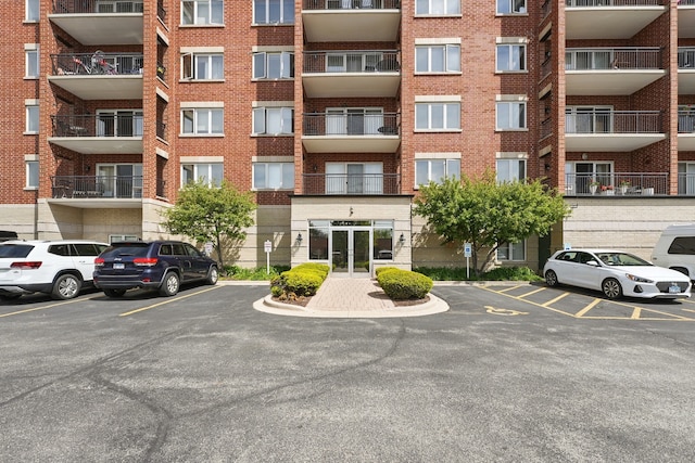 view of apartment building / complex featuring uncovered parking