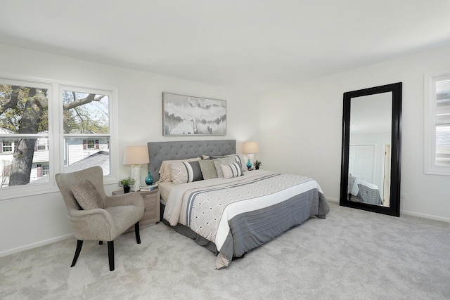 bedroom with light colored carpet and baseboards