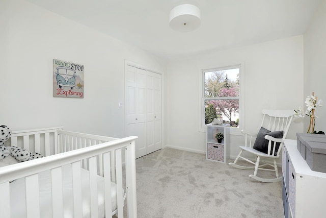 bedroom featuring light colored carpet, a closet, and a crib