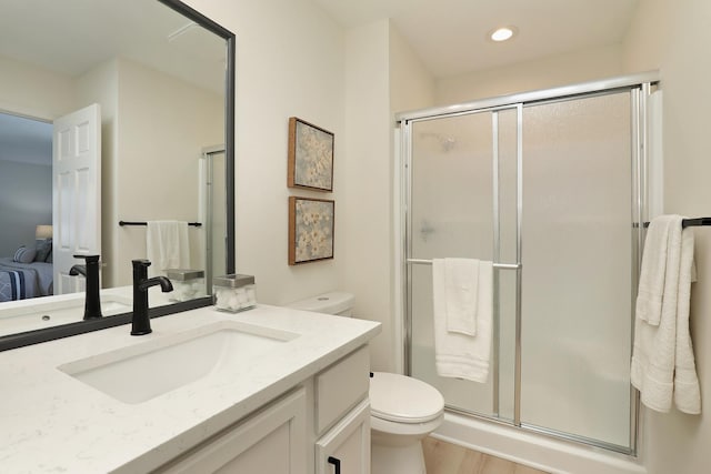 full bath with toilet, a shower stall, vanity, wood finished floors, and recessed lighting