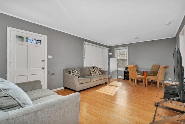 living room featuring crown molding, wood finished floors, and baseboards
