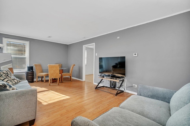 living area with crown molding, wood finished floors, and baseboards