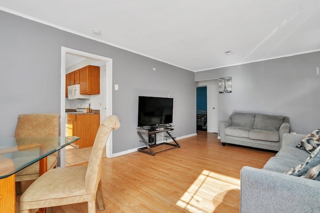 living room with crown molding, light wood-style flooring, and baseboards