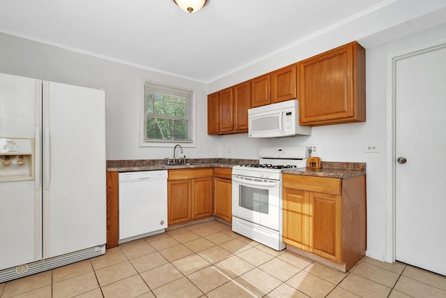 kitchen featuring white appliances, a sink, dark countertops, light tile patterned floors, and ornamental molding