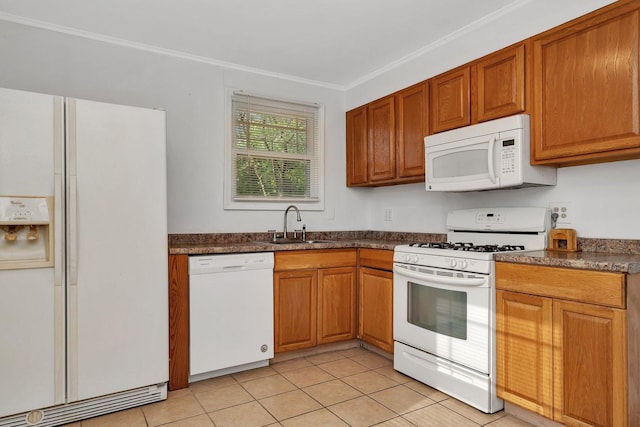 kitchen featuring white appliances, dark countertops, a sink, light tile patterned floors, and crown molding
