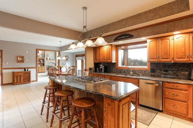 15521 S Mallard Ln, Homer Glen, IL 60491 - kitchen featuring stainless steel appliances, a sink, a breakfast bar, tasteful backsplash, and brown cabinets