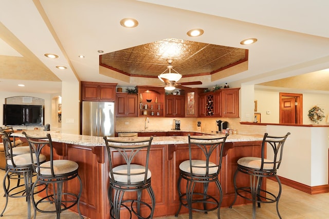 15521 S Mallard Ln, Homer Glen, IL 60491 - kitchen featuring stainless steel fridge, a tray ceiling, backsplash, glass insert cabinets, and recessed lighting