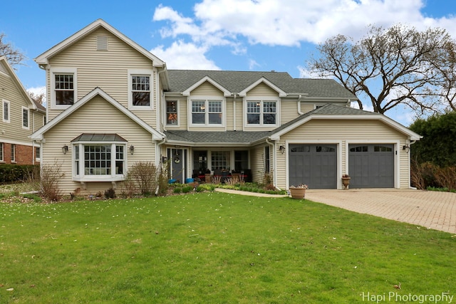 2114 Prairie St, Glenview, IL 60025 - view of front of house featuring a front yard, driveway, a garage, covered porch, and a shingled roof