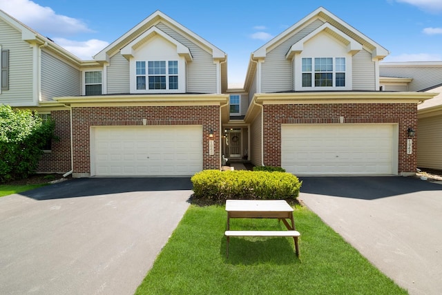 multi unit property with asphalt driveway, a garage, and brick siding