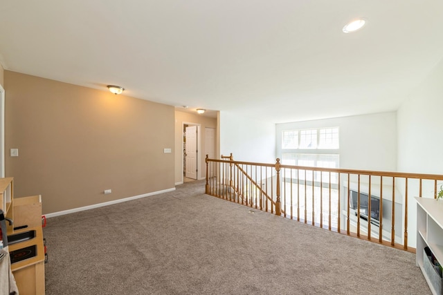 corridor with carpet flooring, an upstairs landing, and baseboards
