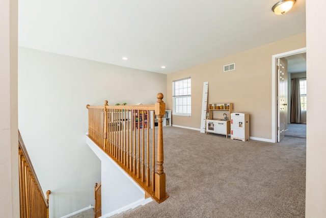 hallway featuring an upstairs landing, carpet floors, baseboards, and recessed lighting