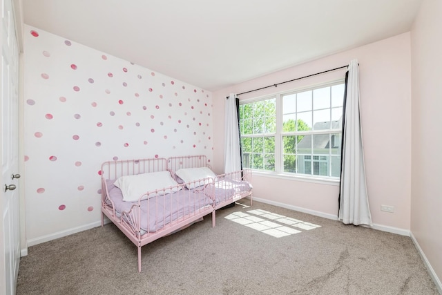 carpeted bedroom with baseboards and wallpapered walls