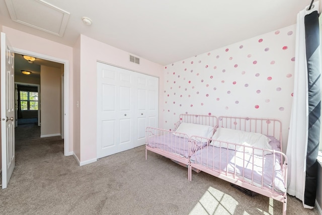 bedroom with carpet, a closet, baseboards, and attic access